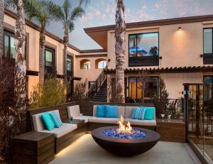 a patio with a fire pit in front of a house at The Cove Hotel in Long Beach