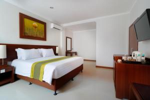 Postel nebo postele na pokoji v ubytování Adi Dharma Hotel Legian