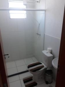 a white bathroom with a toilet and a sink at Apto Oniz Campos X in Campos dos Goytacazes