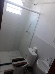 a white bathroom with a toilet and a sink at Apto Oniz Campos X in Campos dos Goytacazes +12 photos