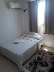 a bedroom with two beds and a window at Apto Oniz Campos X in Campos dos Goytacazes