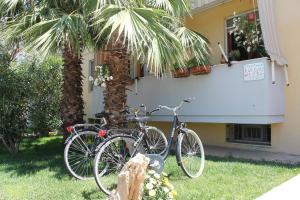 two bikes parked next to a house with a palm tree at Algherooms in Alghero