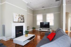 a living room with a couch and a tv at Waterviews - Hidden Gem in CBD - Sleeps 10 in Wagga Wagga