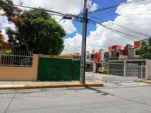 a gate on the side of a street with buildings at Style House in Cancun in Cancún