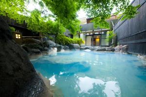 une grande piscine d'eau bleue devant un bâtiment dans l'établissement Yufuin Yasuha, à Yufu