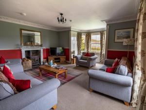 a living room with two couches and a fireplace at Rottal Farmhouse in Millton of Clova