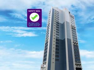 マニラにあるBerjaya Makati Hotelの紫の看板が貼られた高層ビル