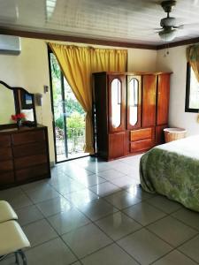 a bedroom with a bed and a dresser and sliding doors at Villa Guarias in Puntarenas