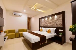 a hotel room with a bed and a chair at Hotel BV Colours Bommanahalli in Bangalore