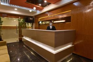 a man in a suit wearing a mask in a lobby at Hotel BV Colours Bommanahalli in Bangalore