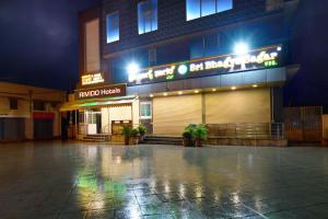 an empty parking lot in front of a building at night at Hotel BV Colours Bommanahalli in Bangalore