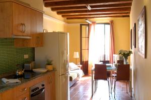 Il comprend une cuisine équipée d'un réfrigérateur et d'une table avec des chaises. dans l'établissement AinB Las Ramblas-Guardia Apartments, à Barcelone