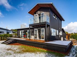 a black house with glass doors and windows at Sunshine and Snow Lodge - Ohakune Holiday Home in Ohakune
