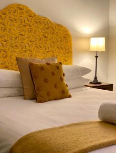アララトにあるThe Barkly Bistro Bar & Accommodationのベッドルーム1室(大型ベッド1台、黄色のヘッドボード付)