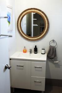 y baño con lavabo blanco y espejo. en Investigator Beach Breeze Apartments U2, en Kingscote