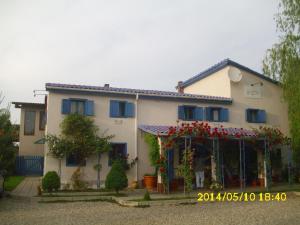 a white house with red flowers in front of it at Pension Giulia in Timişoara