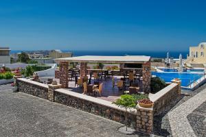 un restaurant avec des tables et des chaises dans un bâtiment dans l'établissement Hotel Star Santorini, à Megalochori