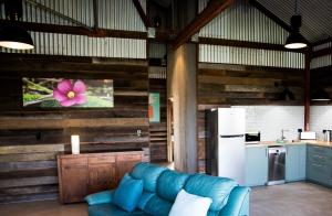 a living room with a blue couch and a refrigerator at Idlewild Bridgetown in Bridgetown
