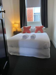 アララトにあるThe Barkly Bistro Bar & Accommodationのベッドルーム(ピンクの枕が付く大きな白いベッド付)