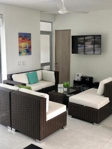 a living room with wicker chairs and a couch at Hermosa Casa de Descanso en Peñalisa in Ricaurte