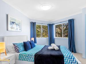 1 dormitorio con 1 cama y 2 ventanas en Broughton No 1 Ondine Close Nelson Bay, en Nelson Bay