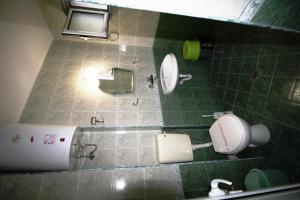 ラブダにあるゾヤ ゲスト ハウスの緑のタイル張りのバスルーム(トイレ2つ、鏡付)
