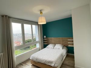 1 dormitorio con cama y ventana grande en Le Majestic idéal famille, entreprise, proximité centre, fac Jean monnet, en Saint-Étienne