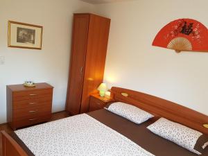 ein Schlafzimmer mit einem Bett und einer Kommode in der Unterkunft Vukovarska Rose in Kaštela