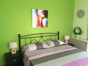 a bedroom with a bed with a green wall at Kalimera Apartment in Nafplio