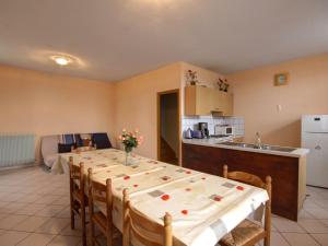uma cozinha com uma mesa longa com cadeiras e uma cozinha em Gîte La Chambonie, 4 pièces, 6 personnes - FR-1-496-196 em La Chambonie