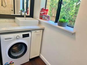 a laundry room with a washing machine and a sink at Stylish Private Studio, Close to Beach, WIFI, Parking in Melbourne