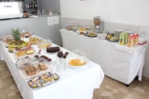 two buffet tables with food and desserts on them at Hotel Luca in Lido di Camaiore