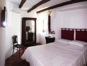 ein Schlafzimmer mit einem Bett, einem Spiegel und einem Stuhl in der Unterkunft L'antica casa-a beautiful view. in Amalfi