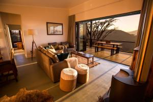 a living room with a couch and a table with a view at Three Tree Hill Lodge in Bergville