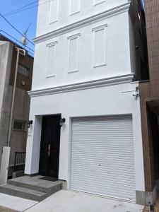 un edificio blanco con una puerta de garaje enrollada en Villa Roppongi, en Tokio
