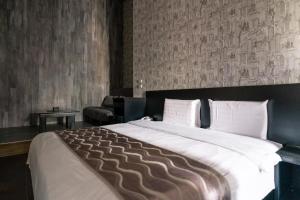 een slaapkamer met een groot bed en een bank bij 58˚ Hotspring Hotel in Jiaoxi