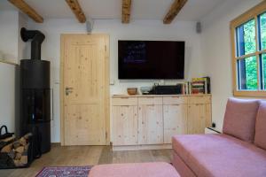 a living room with a flat screen tv and a door at Chalet TISA in Bohinj