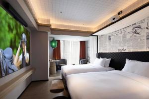 a hotel room with two beds and a wall mural at Arthur Hotel Canton Tower Guangzhou-广州塔骑士物语酒店 in Guangzhou