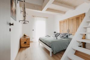 1 dormitorio blanco con 1 cama y escalera en La Tana del Lupo B&B, family and outdoor sports en Borgo