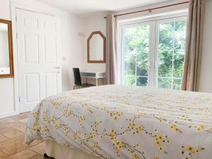a bedroom with a bed and a window at Mill Lodge in Brisley