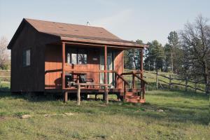 a small cabin with a porch in a field at lake guest ranch in Devils Tower
