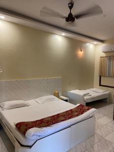 a bedroom with a large white bed with a ceiling at Hotel New Sunder in Indore