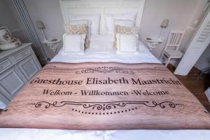 a white bedroom with a large bed with white sheets and pillows at Guesthouse Elisabeth Maastricht in Maastricht