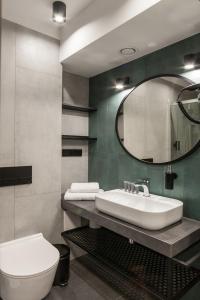 a bathroom with a sink and a toilet and a mirror at Hotel Alexander in Krakow