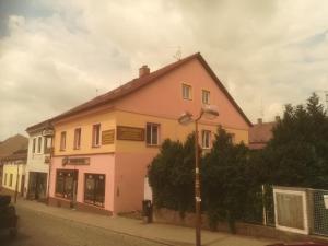 un edificio rosa y blanco en el lateral de una calle en Apartmány pod Barunčinou školou en Česká Skalice