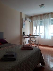 Schlafzimmer mit einem Bett, einem Tisch und einem Fenster in der Unterkunft Almudena Estudio in Torrevieja