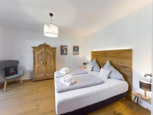 1 dormitorio con 1 cama blanca grande y 1 silla en Olympia 9, en Garmisch-Partenkirchen