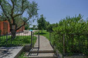 a gate in a park with grass and trees at La Casina Apartment - con giardino e piscina in Pozzolengo