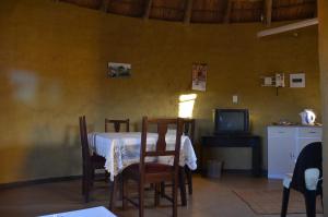 a dining room with a table and chairs and a tv at Bama Lodge in Ohrigstad