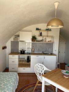 a kitchen with white cabinets and a table in a room at Beach House Loft in Cortegaça